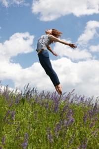 Woman jumping over tall grass